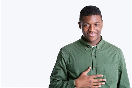 simsearch:693-06379482,k - Portrait of a happy young African American man over gray background Foto de stock - Sin royalties Premium, Código: 693-06379498