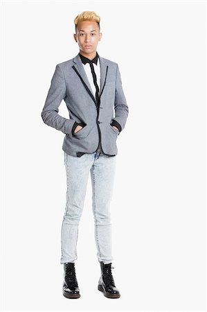 simsearch:693-06379565,k - Portrait of a teenage boy standing in smart casuals over gray background Foto de stock - Sin royalties Premium, Código: 693-06379513