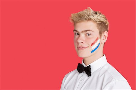 Portrait of a young man with Dutch flag on his face over red background Foto de stock - Sin royalties Premium, Código: 693-06379548