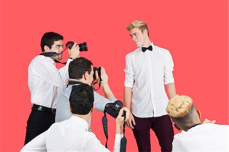 fashion model (male) - Paparazzi taking photographs of male actor over red background Stock Photo - Premium Royalty-Free, Code: 693-06379568