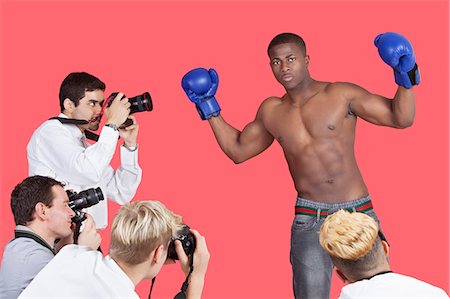 Paparazzi taking photographs of male boxer over red background Foto de stock - Sin royalties Premium, Código: 693-06379569