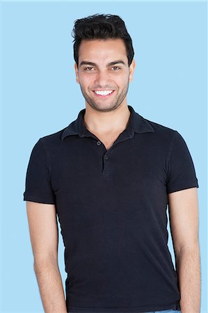 Portrait of a handsome man smiling over blue background Stock Photo - Premium Royalty-Free, Code: 693-06379608