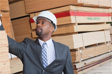 simsearch:693-06379667,k - African American male engineer inspecting wooden planks Foto de stock - Sin royalties Premium, Código: 693-06379700