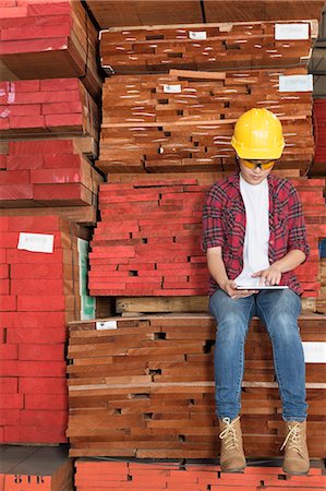 simsearch:693-06379667,k - Asian female industrial worker using tablet PC while sitting on stacked wooden planks Foto de stock - Sin royalties Premium, Código: 693-06379736