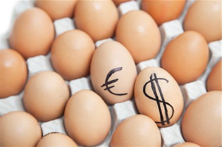 Dollar and euro sign on eggs surrounded by plain brown eggs in carton Stock Photo - Premium Royalty-Free, Code: 693-06379773