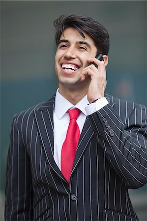 simsearch:693-06379784,k - Happy Indian businessman communicating on cell phone Fotografie stock - Premium Royalty-Free, Codice: 693-06379825