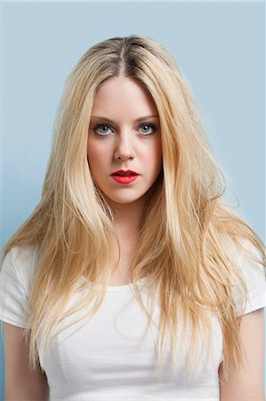 portrait - Portrait of attractive young blond woman with red lips against light blue background Stock Photo - Premium Royalty-Free, Code: 693-06379979
