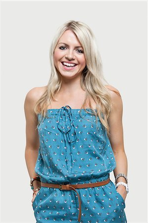 rubio - Portrait of happy young woman in jump suit over gray background Foto de stock - Sin royalties Premium, Código: 693-06380028