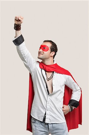 red capes - Young man in superhero costume standing against gray background Stock Photo - Premium Royalty-Free, Code: 693-06380036