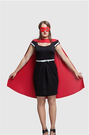 simsearch:693-06380041,k - Young woman standing in superhero costume over gray background Stock Photo - Premium Royalty-Free, Code: 693-06380083