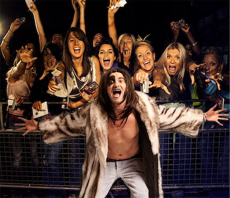 rock and roll - Portrait of young man in fur coat screaming with excited audience in the background Foto de stock - Sin royalties Premium, Código: 693-06403189