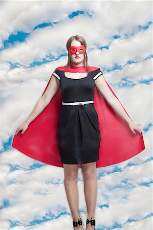 female superhero - Portrait of young woman in superhero costume against cloudy sky Stock Photo - Premium Royalty-Free, Code: 693-06403209