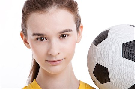 football practice - Portrait of young woman with soccer ball against white background Stock Photo - Premium Royalty-Free, Code: 693-06403247