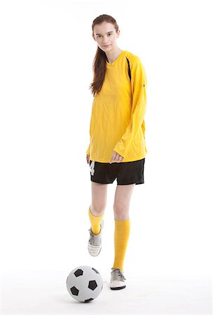 soccer white background - Portrait of young female soccer player kicking the ball against white background Stock Photo - Premium Royalty-Free, Code: 693-06403248