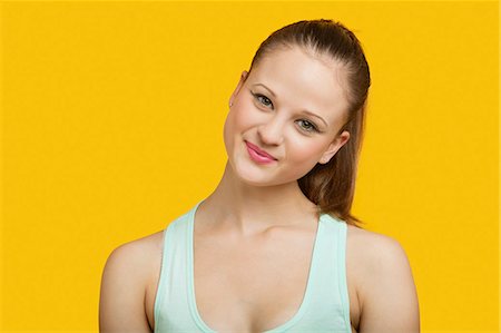 Portrait of beautiful young woman smiling over yellow background Stock Photo - Premium Royalty-Free, Code: 693-06403277