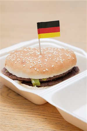 Fresh hamburger with German flag decoration on wooden surface Stock Photo - Premium Royalty-Free, Code: 693-06403333