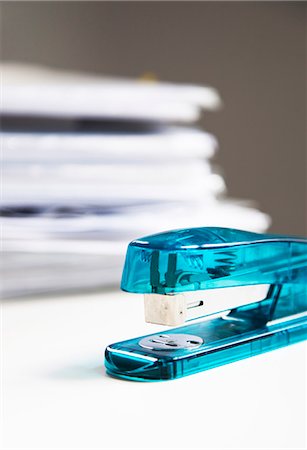 Stapler on white table with stack of papers in background Foto de stock - Royalty Free Premium, Número: 693-06403349