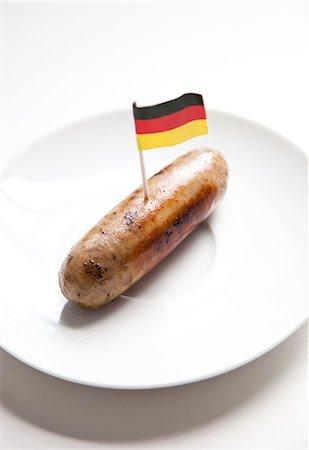 simsearch:693-06403356,k - Fried sausage in plate with German flag decoration against white background Stock Photo - Premium Royalty-Free, Code: 693-06403361