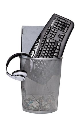 Computer keyboard and headphones in wastebasket against white background Stock Photo - Premium Royalty-Free, Code: 693-06403378