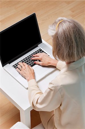 Senior woman surfing the net on laptop at home Foto de stock - Sin royalties Premium, Código: 693-06403447