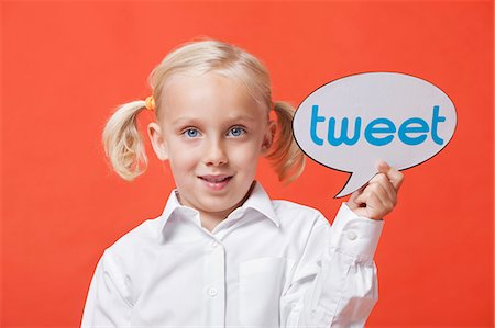simsearch:693-06403587,k - Portrait of a young girl holding tweet bubble against orange background Foto de stock - Sin royalties Premium, Código: 693-06403517