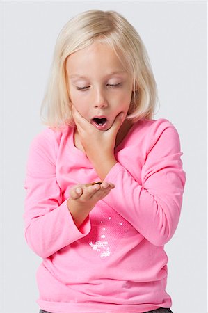 surprise - Choqué jeune fille tenant des pièces de monnaie sur fond blanc Photographie de stock - Premium Libres de Droits, Code: 693-06403518