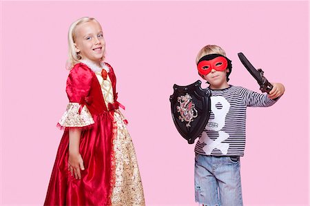 scudo - Portrait of young boy and girl in stage costume over pink background Fotografie stock - Premium Royalty-Free, Codice: 693-06403552