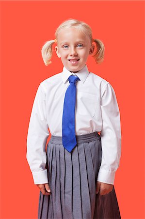 Portrait d'une jeune fille heureuse à l'école uniforme sur fond orange Photographie de stock - Premium Libres de Droits, Code: 693-06403578