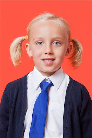 school uniform girl sweater - Portrait of a happy schoolgirl in uniform over orange background Stock Photo - Premium Royalty-Free, Code: 693-06403580