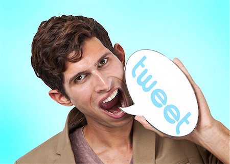 social media - Portrait of young man holding tweet word bubble against white background Stock Photo - Premium Royalty-Free, Code: 693-06435750