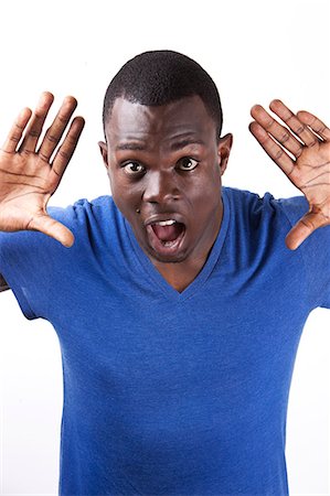 Portrait of shocked young man with palms open standing against white background Foto de stock - Sin royalties Premium, Código: 693-06435767