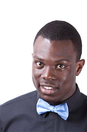 Portrait of happy young African American man in bow tie against white background Stock Photo - Premium Royalty-Free, Code: 693-06435768