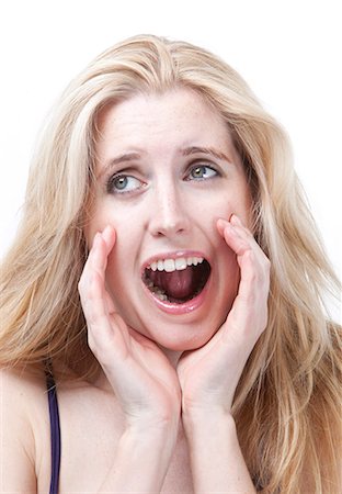 Frustrated young woman screaming against white background Stock Photo - Premium Royalty-Free, Code: 693-06435775