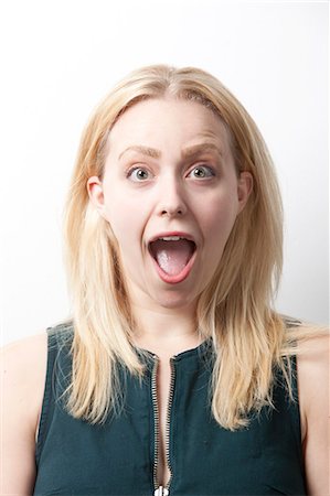 surprised people eye contact - Portrait of shocked young woman screaming against white background Stock Photo - Premium Royalty-Free, Code: 693-06435779