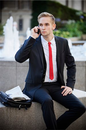 Young businessman sitting on platform while using cell phone Foto de stock - Sin royalties Premium, Código: 693-06435813