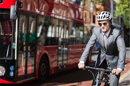 simsearch:693-06403489,k - Young businessman riding bicycle by bus on street Stock Photo - Premium Royalty-Free, Code: 693-06435822