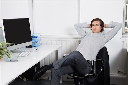 stapler - Portrait of young businessman relaxing on chair with hands behind head in office Foto de stock - Sin royalties Premium, Código: 693-06435835