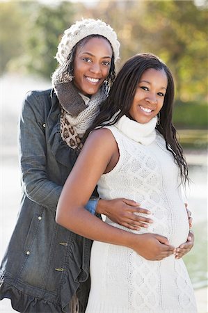 Portrait of happy young female friend embracing pregnant woman from behind Stock Photo - Premium Royalty-Free, Code: 693-06435861