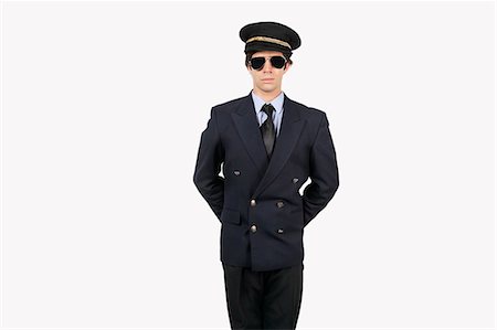 pilote (avion) - Jeune pilote permanent uniforme sur fond gris Photographie de stock - Premium Libres de Droits, Code: 693-06435881