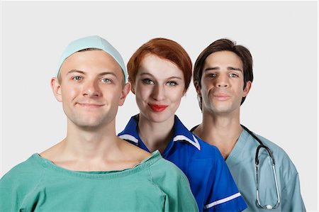 female doctor costume - Portrait of three medical practitioners smiling together against gray background Stock Photo - Premium Royalty-Free, Code: 693-06435924