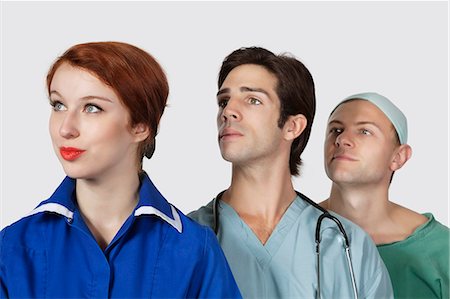 female doctor costume - Three medical practitioners looking away against gray background Stock Photo - Premium Royalty-Free, Code: 693-06435926