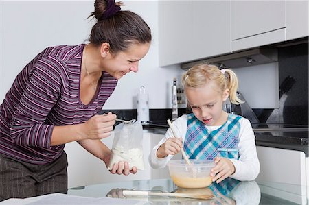 Happy mother and daughter baking together in kitchen Foto de stock - Sin royalties Premium, Código: 693-06435977