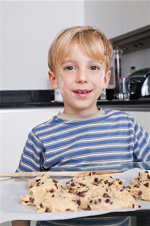 simsearch:693-06435982,k - Portrait d'heureux jeune garçon en face de la plaque à gâteaux de cookies Photographie de stock - Premium Libres de Droits, Code: 693-06435986