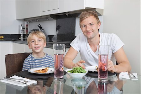 dad and son breakfast - Portrait of father and son smiling at breakfast table Stock Photo - Premium Royalty-Free, Code: 693-06435989