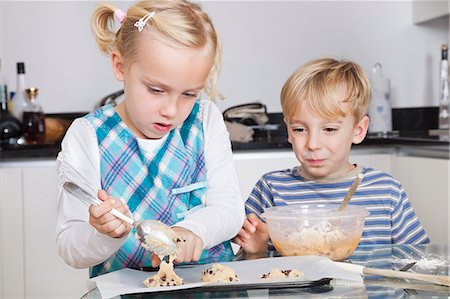 Happy brother and sister baking cookies in kitchen Foto de stock - Sin royalties Premium, Código: 693-06435982