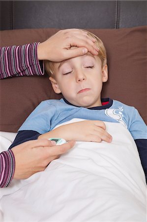 sick child parent - Mother with thermometer checking little boy's temperature Stock Photo - Premium Royalty-Free, Code: 693-06435995