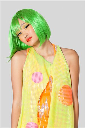 simsearch:693-06324980,k - Portrait of funky young woman with green hair standing against gray background Foto de stock - Sin royalties Premium, Código: 693-06436018