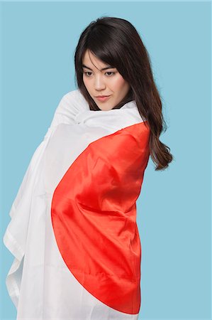 filipino - Patriotic young woman wrapped in Japanese flag over blue background Photographie de stock - Premium Libres de Droits, Code: 693-06497567