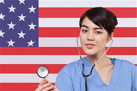 Portrait of mixed race female surgeon standing over American flag Foto de stock - Sin royalties Premium, Código: 693-06497576