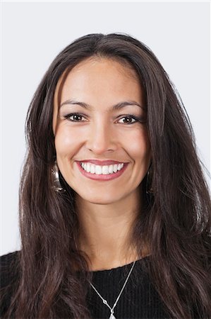 Portrait of smiling young woman over white background Stock Photo - Premium Royalty-Free, Code: 693-06497580